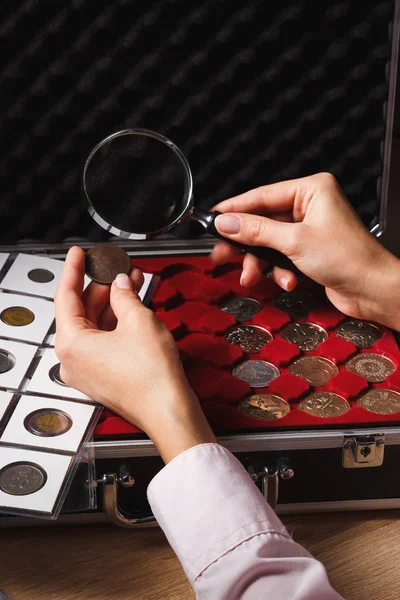 女人看着硬币通过放大镜 — 图库照片