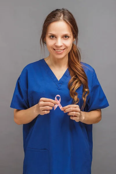 Женщина-врач в форме с розовой лентой — стоковое фото