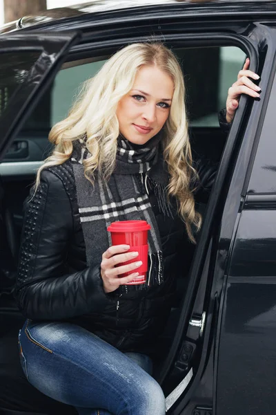 Arabada oturan bir kırmızı Kupası olan kadın