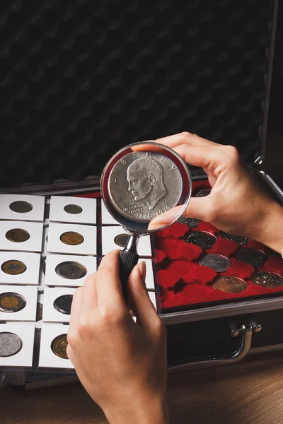 Moneda de dólar en la mano de la mujer a través de la lupa —  Fotos de Stock