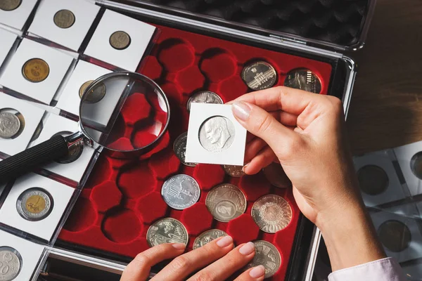 Caja con monedas coleccionables y lupa — Foto de Stock