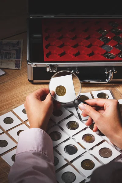 Staré mince v ruce ženy přes zvětšovací sklo — Stock fotografie