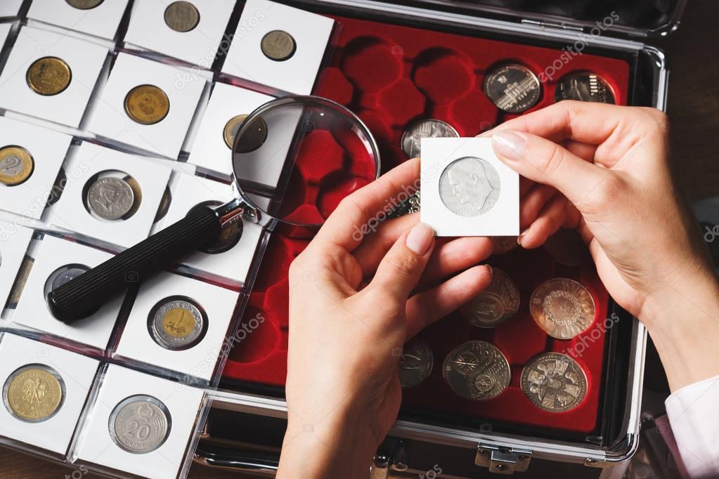 Box with collectible coins and magnifying glass