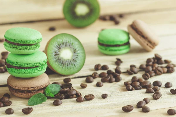 緑と茶色のフランスのキウイ、コーヒー豆とミントの装飾とマカロン — ストック写真