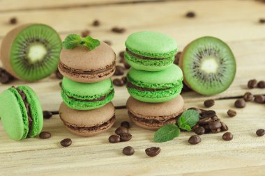 Yeşil ve kahverengi macarons kivi, kahve çekirdekleri ve nane şekeri süslemeleri ile Fransız