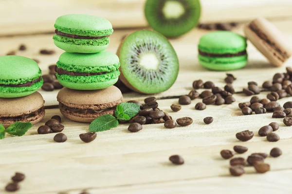 緑と茶色のフランスのキウイ、コーヒー豆とミントの装飾とマカロン — ストック写真