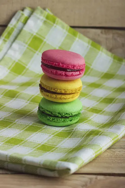Yellow, green and pink macarons on the plaid napkin — Stock Photo, Image