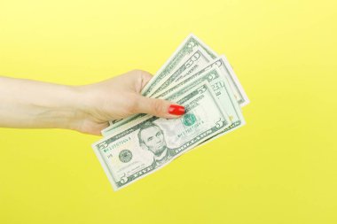 Amerikan Doları olarak kadının el, sarı arka plan