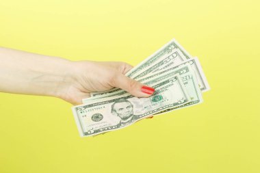 Amerikan Doları olarak kadının el, sarı arka plan