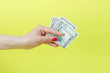 Amerikan Doları olarak kadının el, sarı arka plan