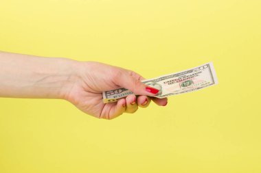 Amerikan Doları olarak kadının el, sarı arka plan