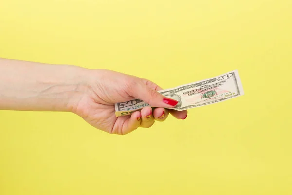 Amerikaanse dollars in de woman's hand, gele achtergrond — Stockfoto