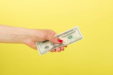 Kadının el, sarı arka planda yirmi dolar