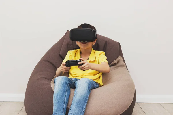 Menino joga jogo com óculos de realidade virtual dentro de casa — Fotografia de Stock