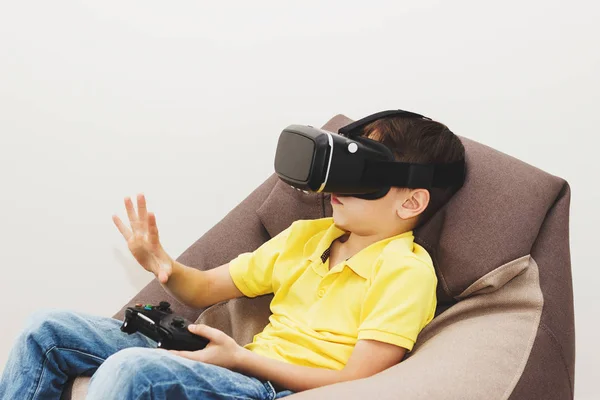 Menino joga jogo com óculos de realidade virtual dentro de casa — Fotografia de Stock
