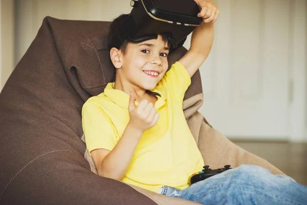 Menino joga jogo com óculos de realidade virtual dentro de casa — Fotografia de Stock