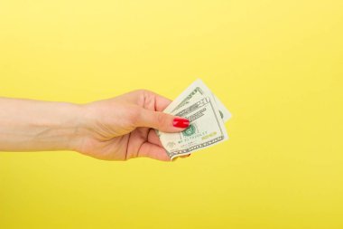 Amerikan Doları olarak kadının el, sarı arka plan