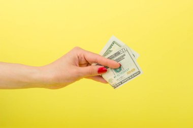 Amerikan Doları olarak kadının el, sarı arka plan