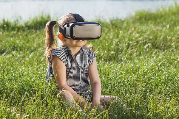 Menina joga jogo com óculos de realidade virtual ao ar livre — Fotografia de Stock