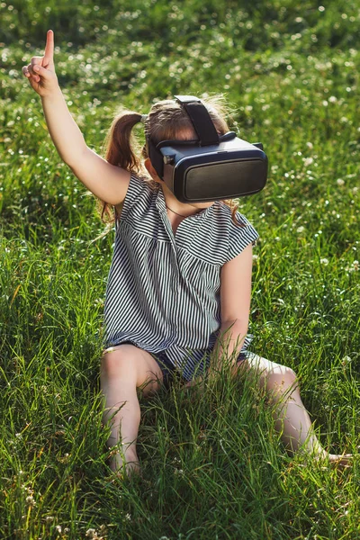 Menina joga jogo com óculos de realidade virtual ao ar livre — Fotografia de Stock