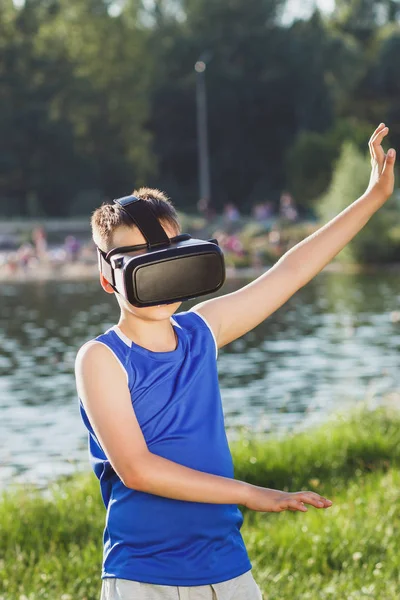 Pojke spelar spelet med virtual reality-glasögon utomhus — Stockfoto