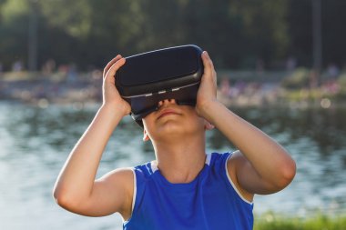 Çocuk açık havada sanal gerçeklik gözlük ile oyun oynuyor