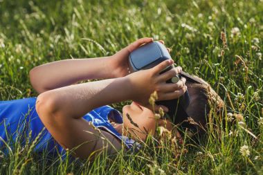 Çocuk açık havada sanal gerçeklik gözlük ile oyun oynuyor