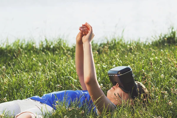 Мальчик играет в игру с очками виртуальной реальности на открытом воздухе — стоковое фото