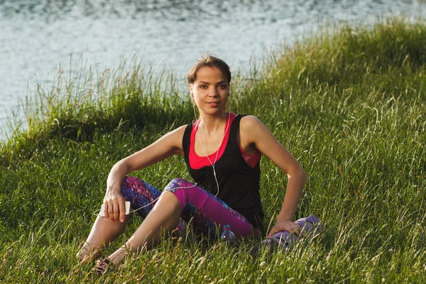 Mujer deportiva en la costa de los lagos hace ejercicios deportivos — Foto de Stock
