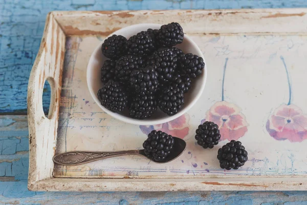 Blackberry in the white bowl with a spoon on the wooden tray — Stock Photo, Image