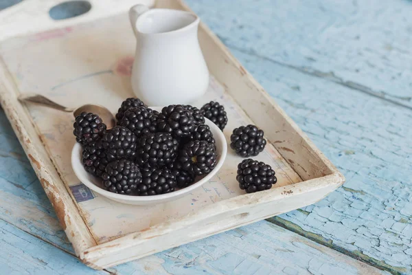 Blackberry in the white bowl with a spoon on the wooden tray — Stock Photo, Image