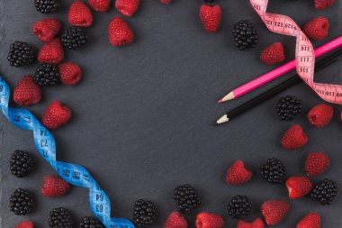 Kırmızı Ahududu, böğürtlen ve siyah arduvaz taş zemin üzerine iki kalem