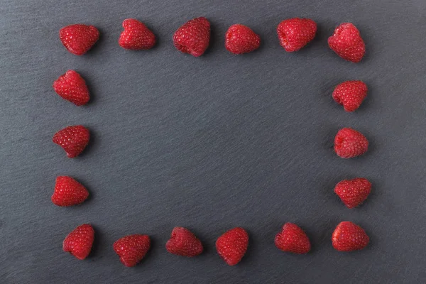 Siyah arduvaz taş zemin üzerine Kırmızı Ahududu çerçevesinden