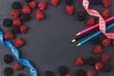 Kırmızı Ahududu, böğürtlen ve siyah arduvaz taş zemin üzerine iki kalem