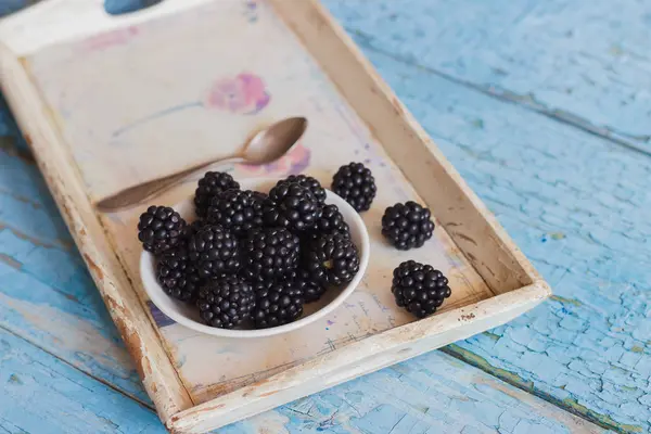 Blackberry in the white bowl on the wooden tray — Stock Photo, Image