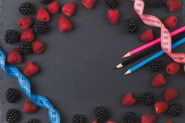 Kırmızı Ahududu, böğürtlen ve siyah arduvaz taş zemin üzerine iki kalem