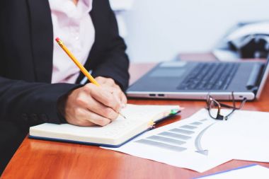 Bir kalem, not defteri ve birkaç grafikler ile el