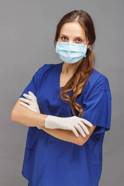 Kadın doktor mavi üniforma ve yüzünde maske — Stok fotoğraf