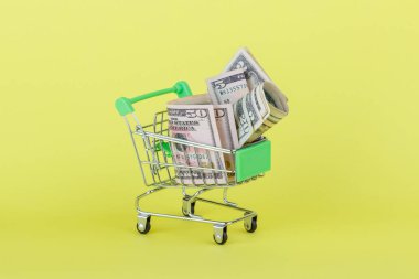 Amerikan Doları olarak alışveriş itme sepeti, sarı arka plan