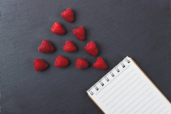 Kırmızı Ahududu, mezura, defter siyah arduvaz taş zemin üzerine