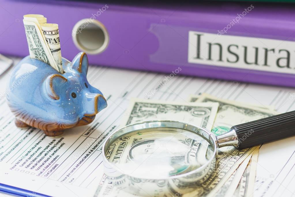Folders, piggy bank with dollars and magnifying glass