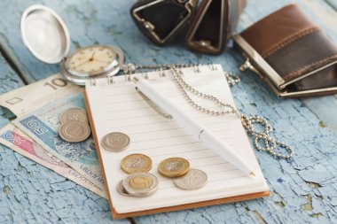 Polonya Zlotisi, defter ve çalar saat ahşap arka plan üzerinde