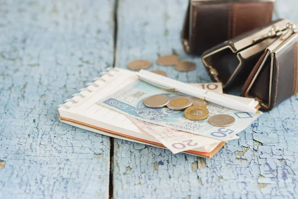 Zloty polaco con carteras y cuaderno en el fondo de madera — Foto de Stock