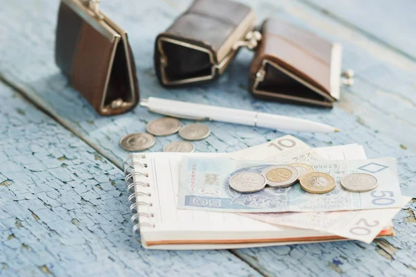 Zloty polaco con carteras y cuaderno en el fondo de madera — Foto de Stock