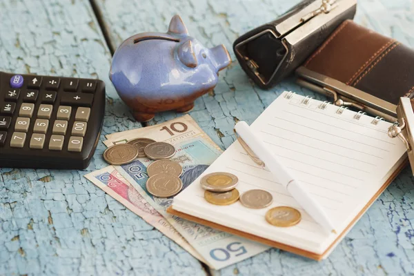 Zloty polaco, carteras, alcancía, cuaderno y calculadora, fondo de madera — Foto de Stock