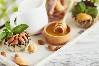 Tatlım ahşap kase, nane yaprakları, badem ve süt ile kavanoz