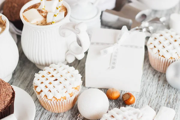 Kupit kaakao ja vaahtokarkki, cupcakes ja erilaisia joulukoristeita, puinen tausta — kuvapankkivalokuva