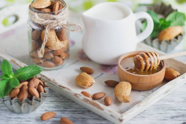 Badem, bal kase, nane yaprağı, kavanoz süt ve farklı süslemeler