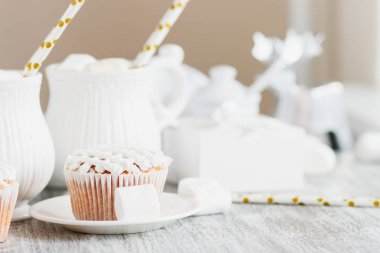 Su bardağı kakao ve şekerleme, kek ve farklı süslemeler, ahşap arka plan ile