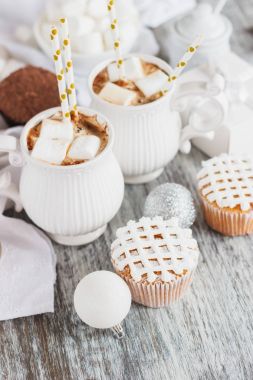 Su bardağı kakao ve şekerleme, kek ve farklı Noel süsleri, ahşap arka plan ile